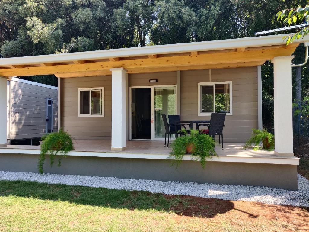 een huis met een veranda met een tafel en stoelen bij Dolores ONLY 250 METERS TO THE BEACH in Banjole