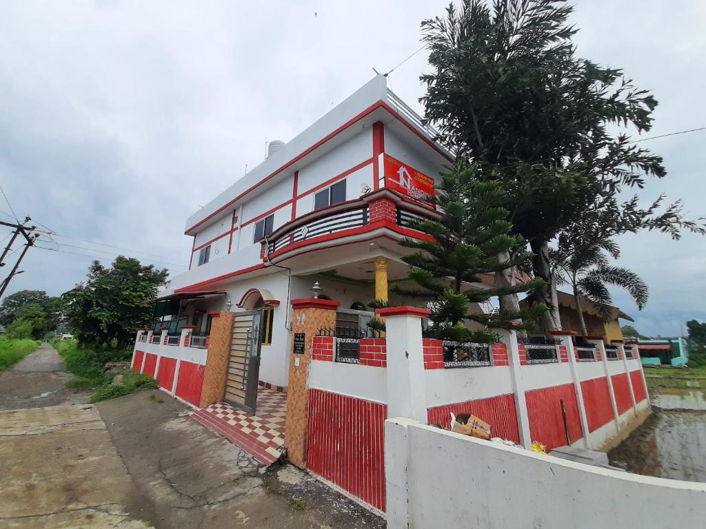 una casa roja y blanca con una valla en Nandini Homestay en Dehradun