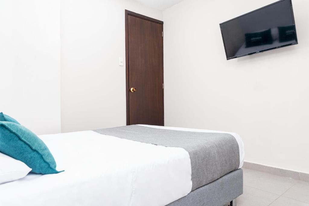 a bedroom with a bed and a tv on a wall at Casa Prado 59 in Barranquilla