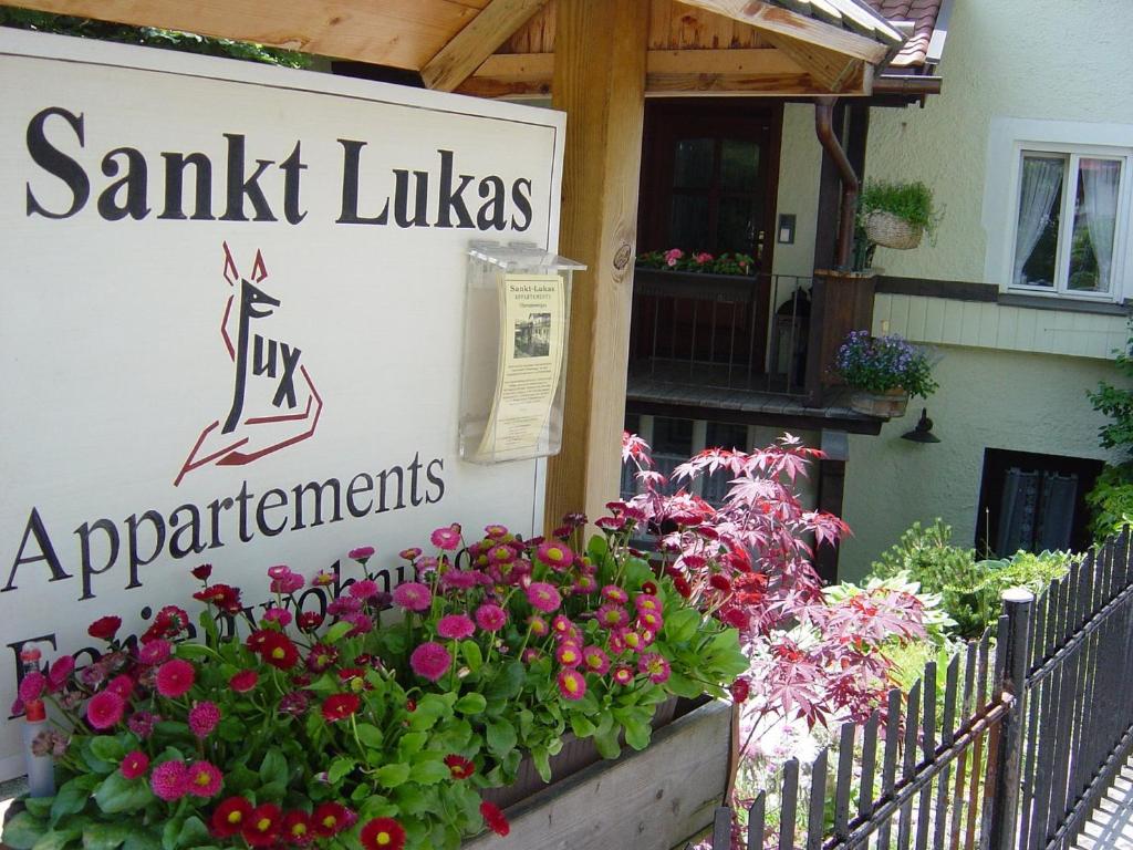 a sign for a shop with flowers in front of it at St Lukas Apartments in Oberammergau