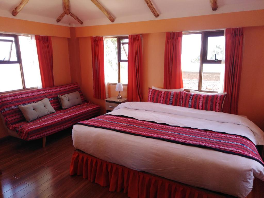 a bedroom with red curtains and a bed and a couch at "Casa de Valentin" in Llachon