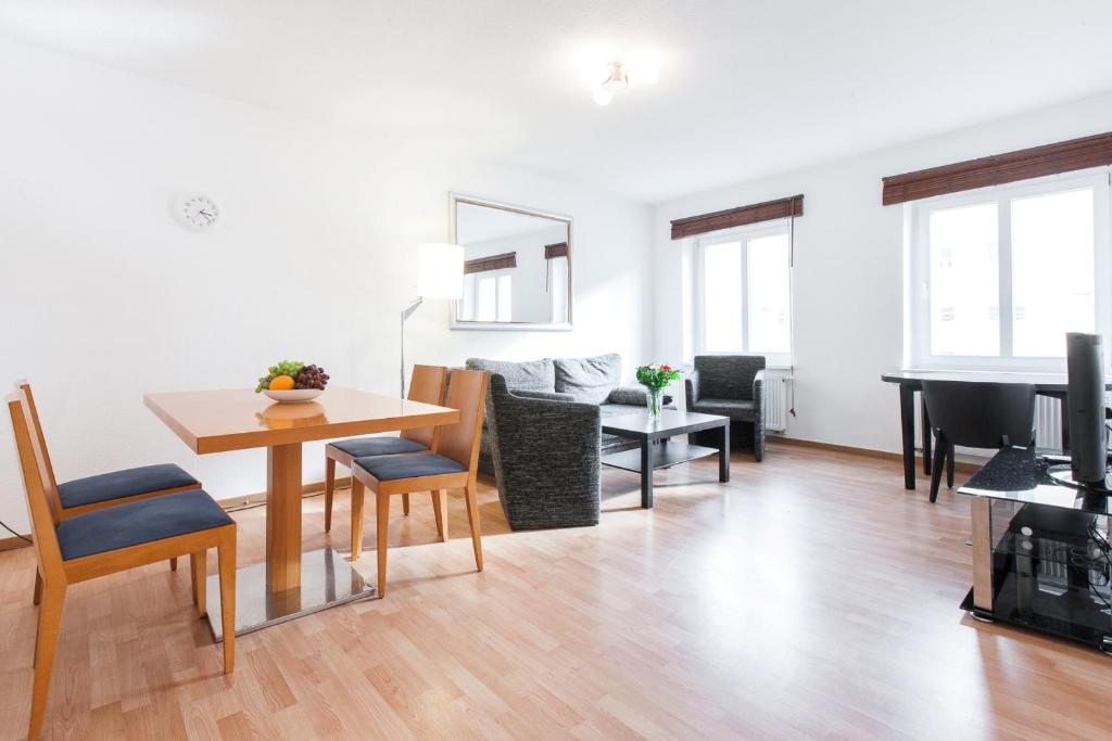 ein Wohnzimmer mit einem Tisch und einem Klavier in der Unterkunft BerlinLux Apartments - Mitte in Berlin