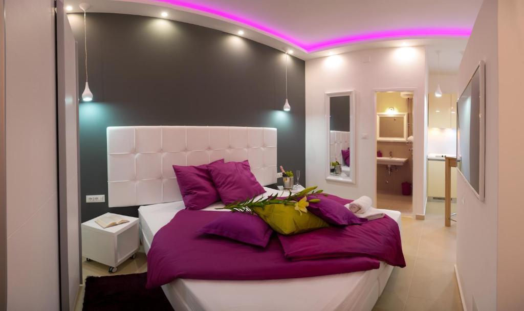 1 dormitorio con 1 cama grande con almohadas moradas en Apartment Joe, en Split