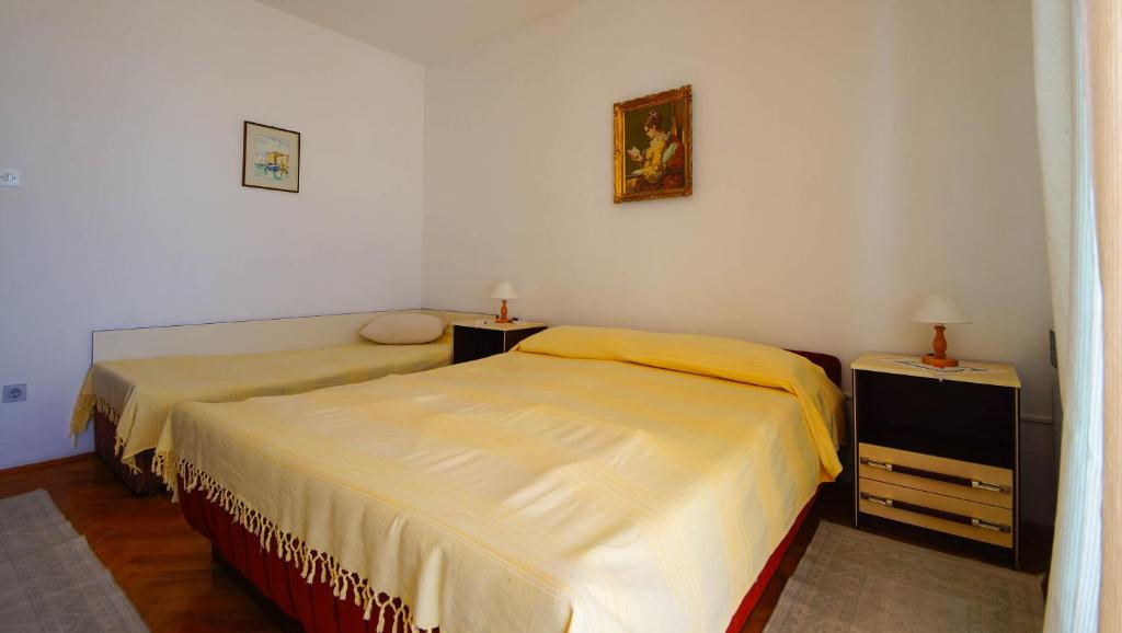 1 dormitorio con 2 camas y 2 mesitas de noche en Apartments Lina, en Novi Vinodolski