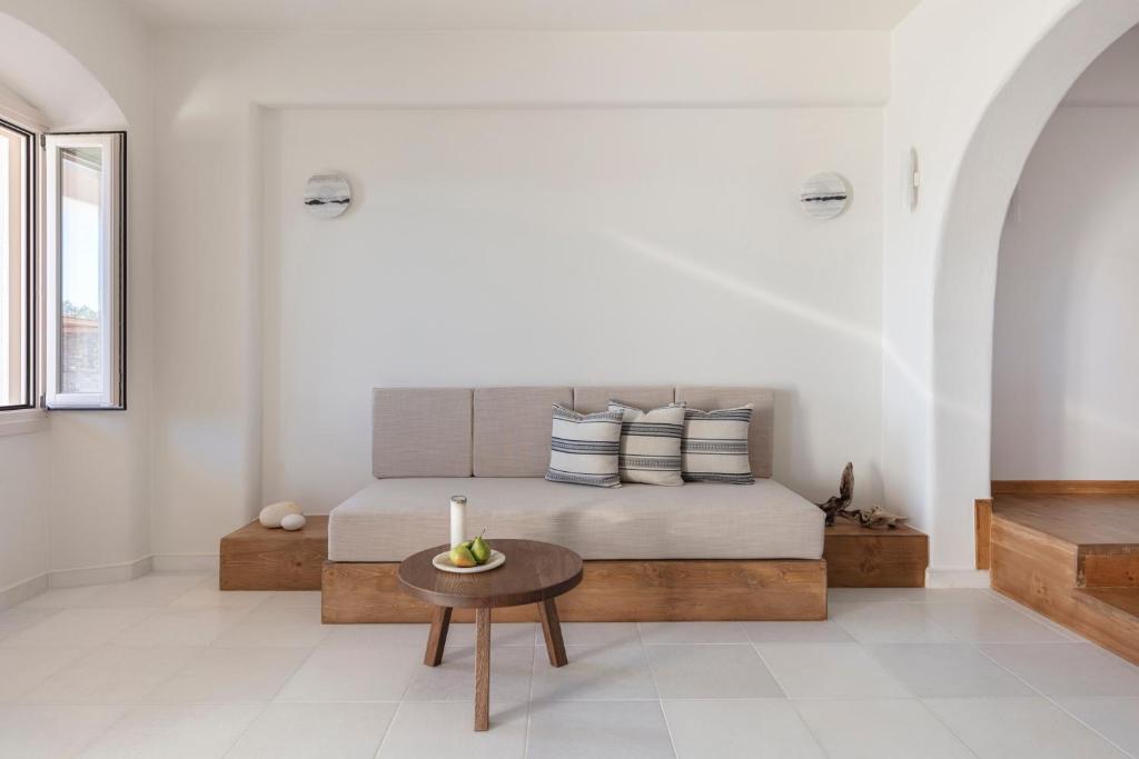 a bedroom with a bed with a candle on a table at Ammothines Cycladic Suites in Naxos Chora