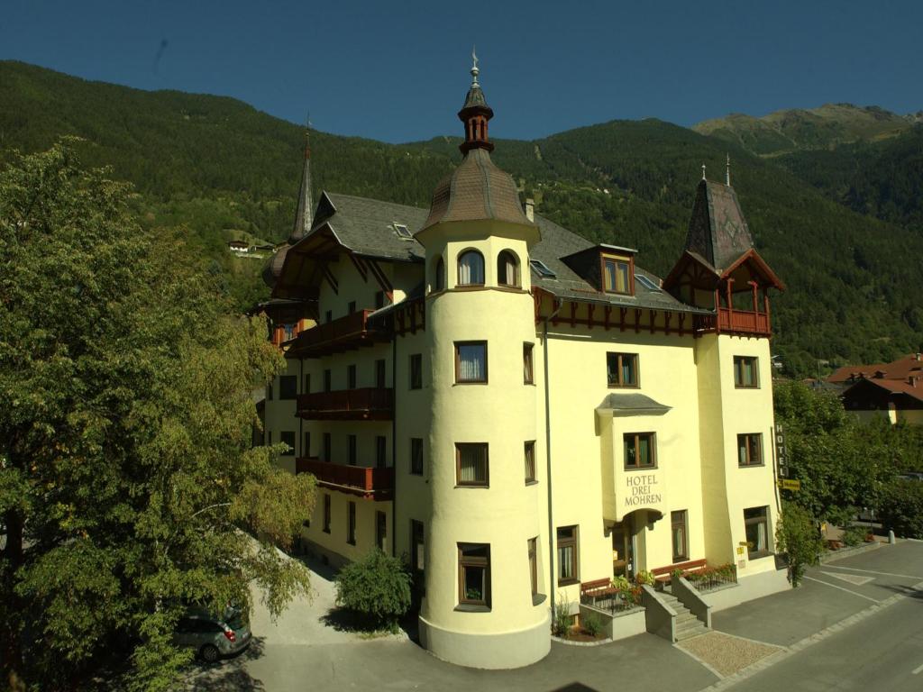 a large white building with a tower on top of it at Hotel 3 Mohren in Oetz