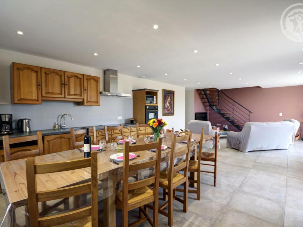 a kitchen and dining room with a wooden table and chairs at Gîte Panissières, 3 pièces, 8 personnes - FR-1-496-215 in Panissières