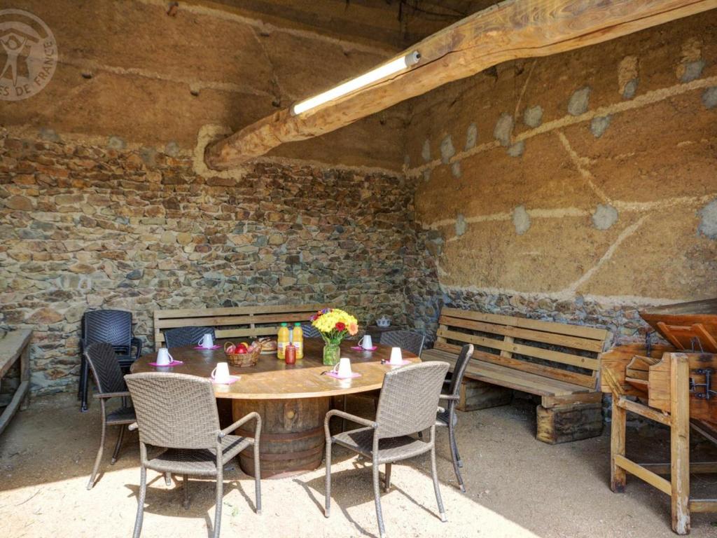 a table and chairs in a room with a brick wall at Gîte Panissières, 3 pièces, 8 personnes - FR-1-496-215 in Panissières