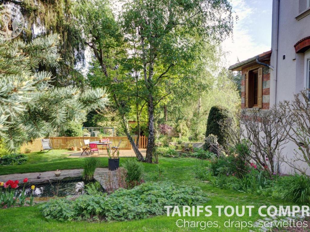 un jardin avec un étang et une maison dans l'établissement Appartement Andrézieux-Bouthéon, 2 pièces, 2 personnes - FR-1-496-194, à Andrézieux-Bouthéon