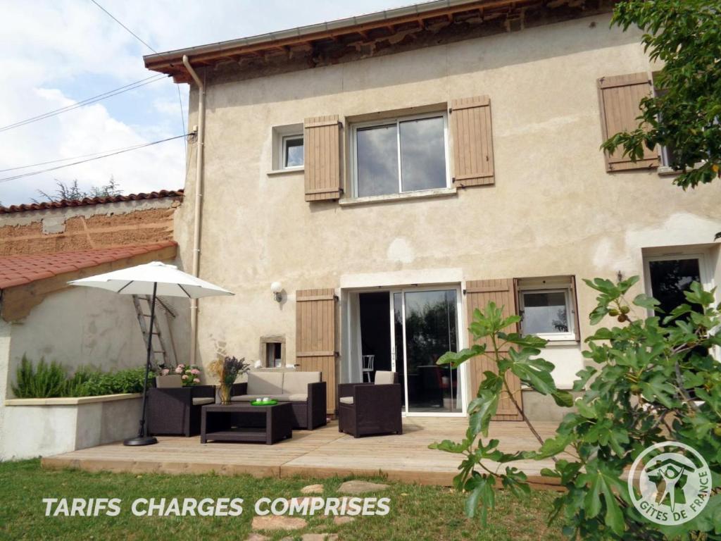 een huis met een patio en een parasol bij Gîte Maringes, 3 pièces, 4 personnes - FR-1-496-174 in Maringes