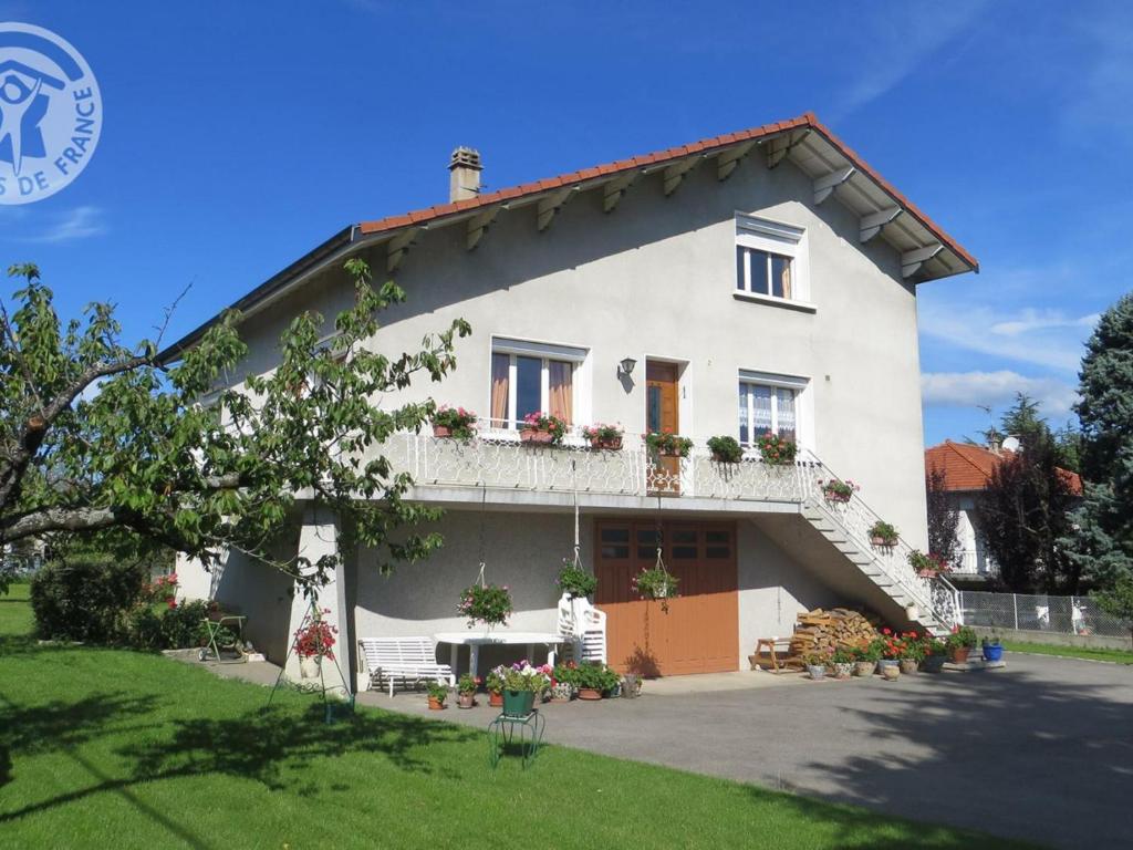 ein weißes Haus mit Blumen auf der Vorderseite in der Unterkunft Gîte Lorette, 3 pièces, 2 personnes - FR-1-496-76 in Lorette