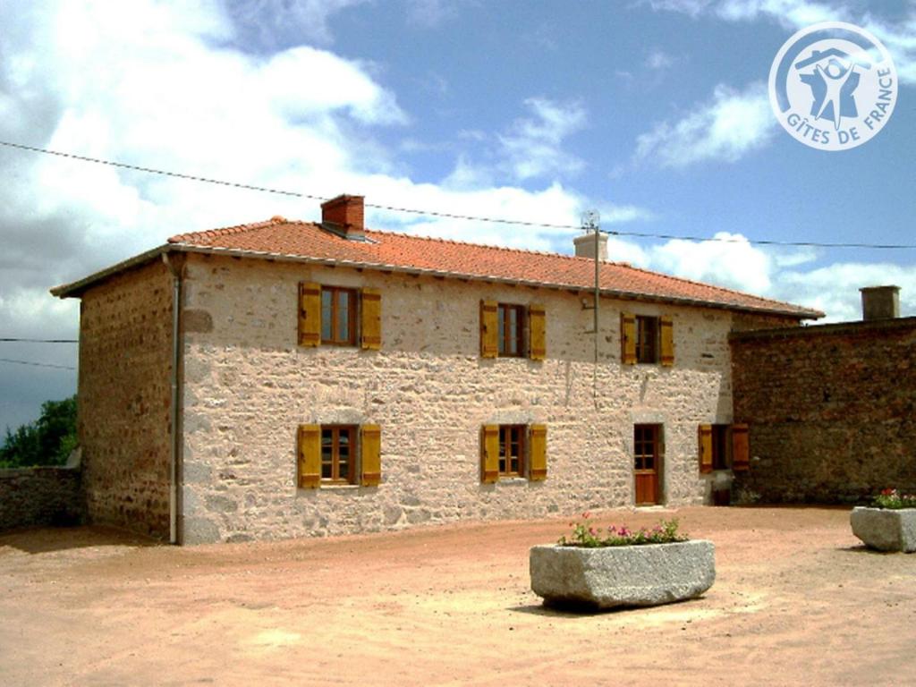 a stone house with windows on a dirt yard at Gîte Le Crozet, 5 pièces, 12 personnes - FR-1-496-100 in Le Crozet