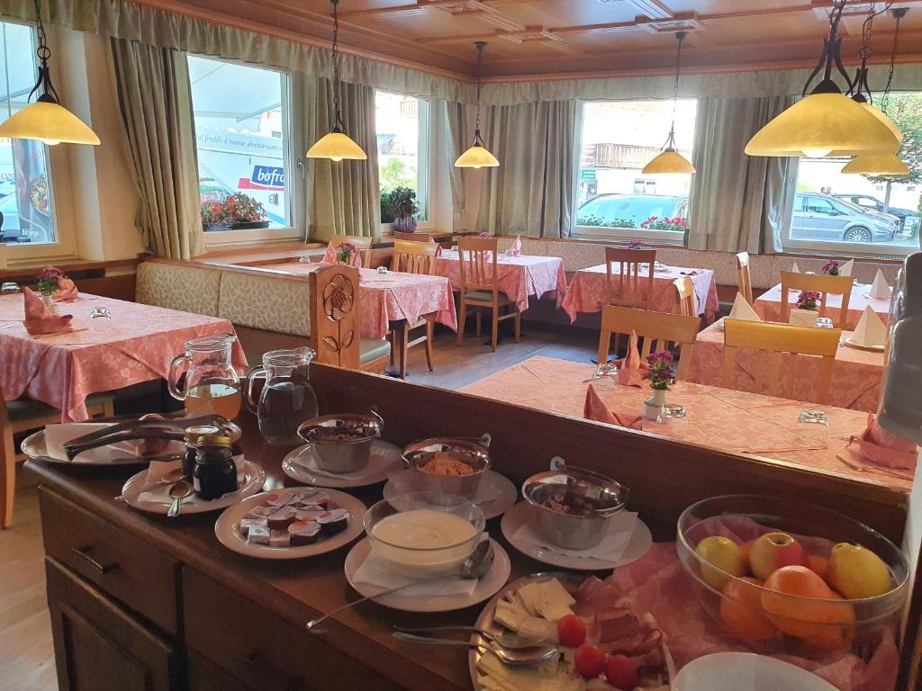- une salle à manger avec une table et de la nourriture dans l'établissement ALBERGO BAR RISTORANTE DOLOMIA, à Badia