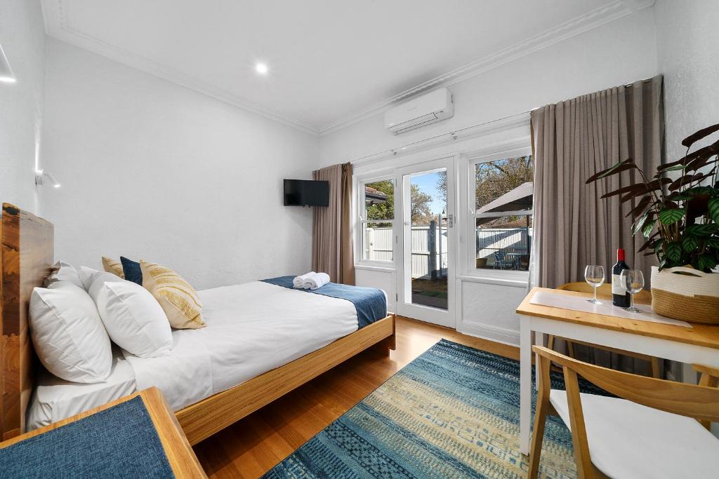 a bedroom with a bed and a window at Benson House & Benson Lodge in Benalla