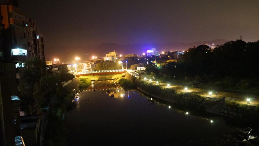 a bridge over a river in a city at night at 甘丹民宿-三義火車站前 in Sanyi