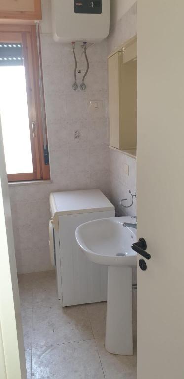 łazienka z białą umywalką i lustrem w obiekcie Residence Mediterranea w mieście Campomarino