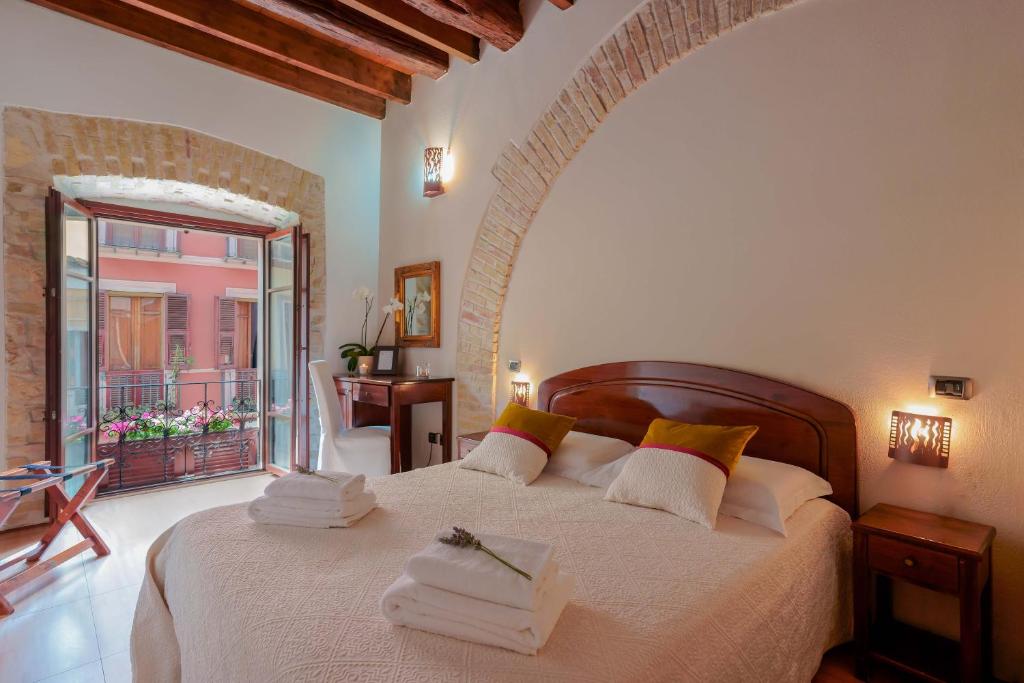 a bedroom with a large bed with towels on it at Sa Domu Cheta in Cagliari