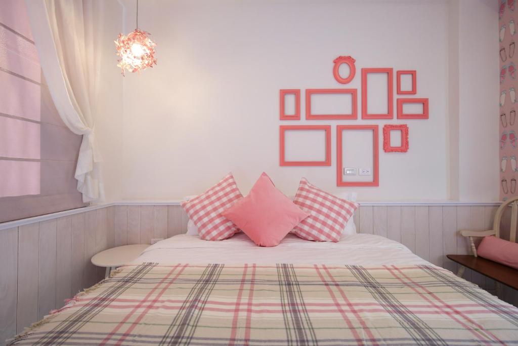 a bedroom with a bed with pink pillows on it at 1999 B&amp;B in Hualien City