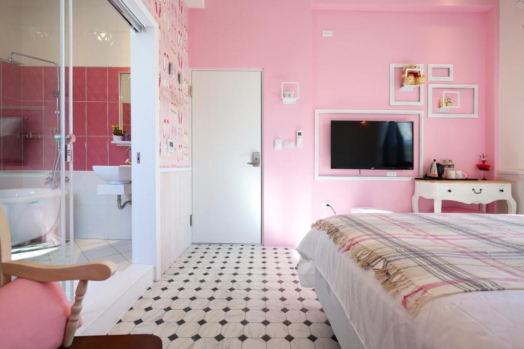 a pink bedroom with a bed and a bathroom at 1999 B&amp;B in Hualien City