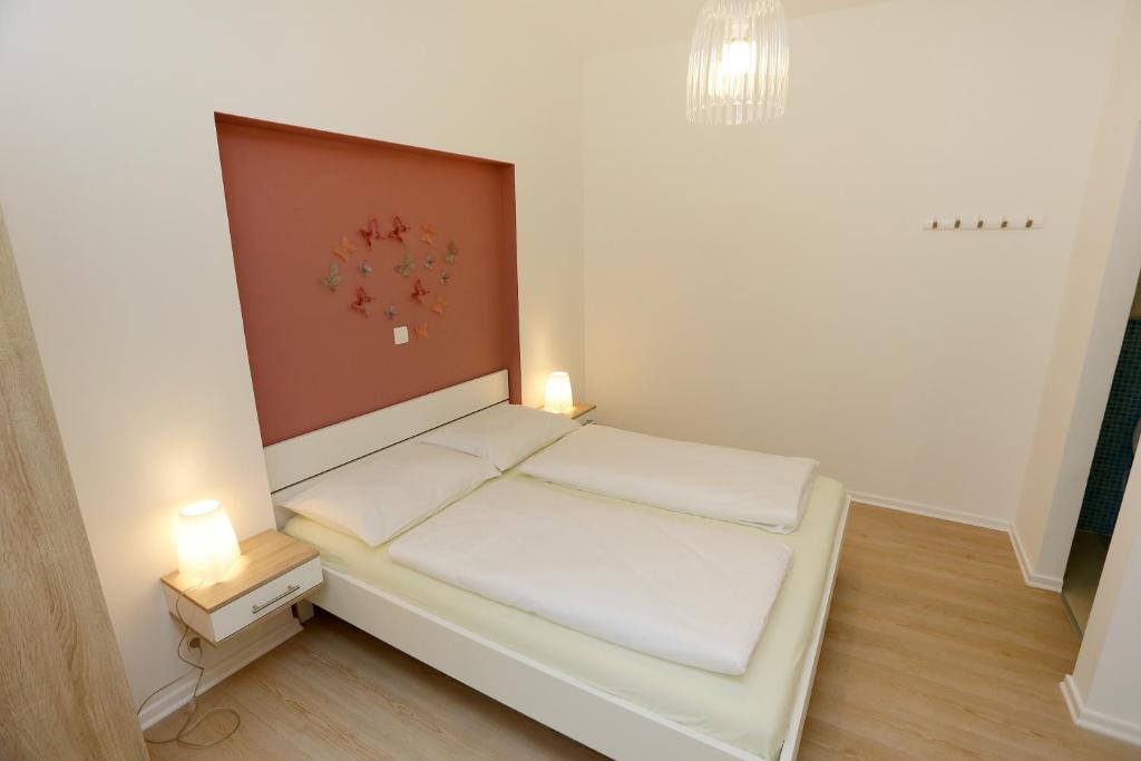 een kleine kamer met een bed met twee verlichting bij Zadar Street Apartments and Room in Zadar