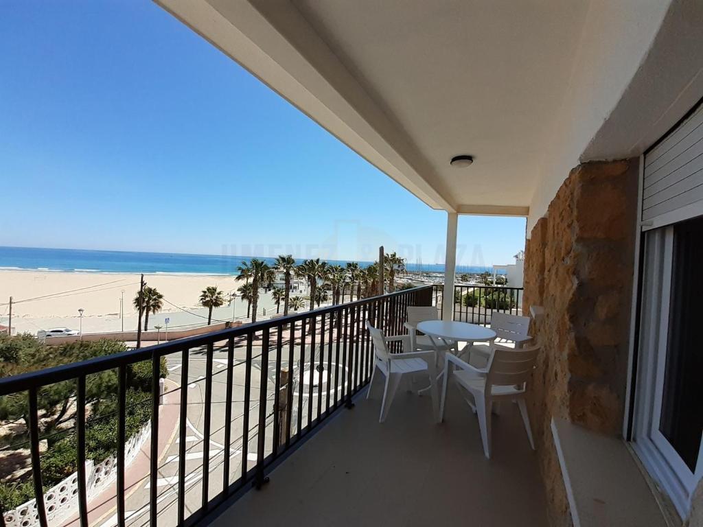 einen Balkon mit Tisch und Stühlen sowie Strand in der Unterkunft Apartamentos Dins Mar Apto. 8 in Torredembarra