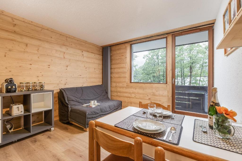 un soggiorno con tavolo e divano di Chamonix Sud - Grepon 102 - Happy Rentals a Chamonix-Mont-Blanc