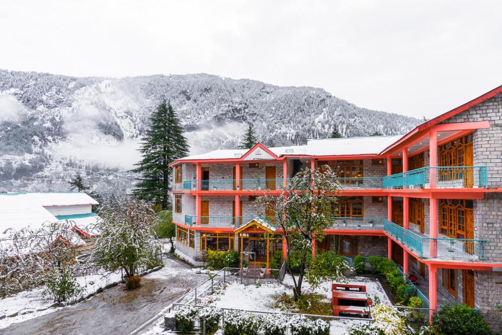a large building with snow on top of it at Keekoo Manali - Private Rooms & Dorms in Manāli