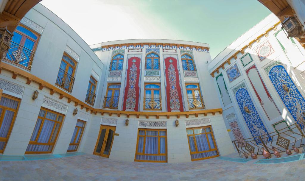 um grande edifício com janelas e portas coloridas em Al Imran Boutique Hotel em Bukhara