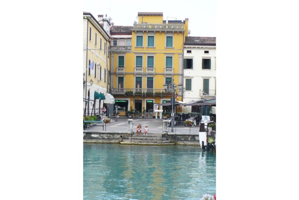 vista para um canal numa cidade com edifícios em Aparthotel All'Orologio em Peschiera del Garda