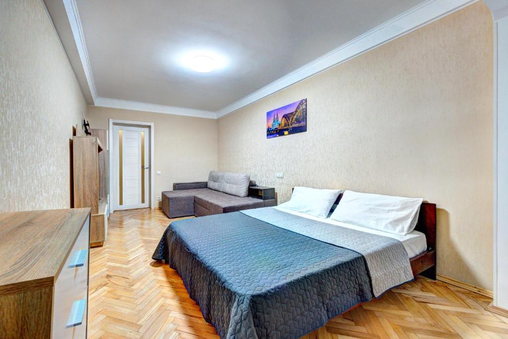 ein Hotelzimmer mit einem Bett und einem Sofa in der Unterkunft Apartments near Ocean Plaza Druzhby Narodov Boulevard 8a in Kiew