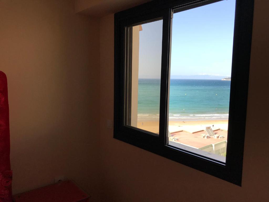 Cette chambre dispose d'une fenêtre offrant une vue sur la plage. dans l'établissement appartement 69 vue sur mer 3 chambre, à Tanger