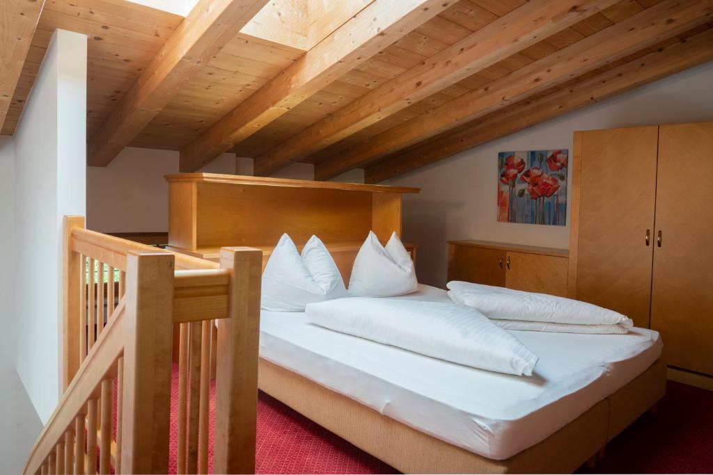 ein Schlafzimmer mit einem Bett mit weißen Kissen in der Unterkunft Aparthotel Schindlhaus/Alpin in Söll