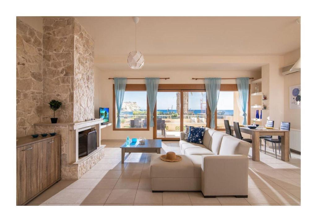 ein Wohnzimmer mit einer weißen Couch und einem Kamin in der Unterkunft Beachfront Blue apt-Ligaria beach in Ligaria