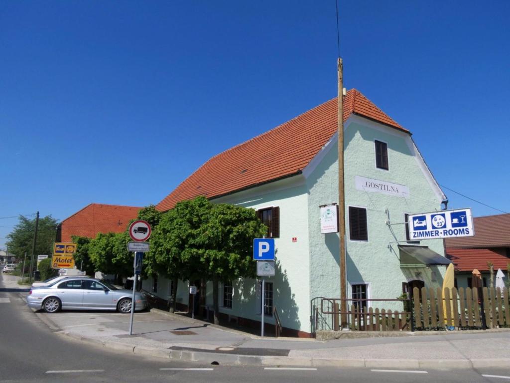 un edificio blu e bianco con un'auto parcheggiata di fronte di Motel Divjak a Spodnje Hoče