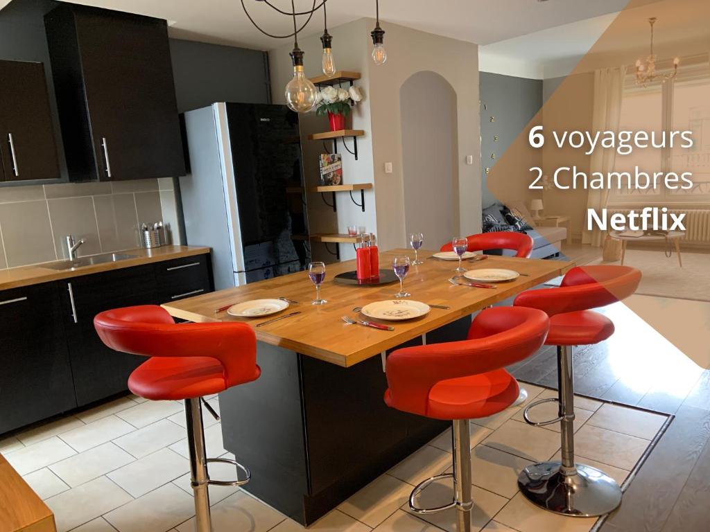 a kitchen with a wooden table and red chairs at Le Saint-Bernard in Metz