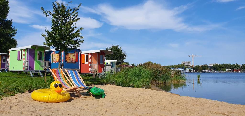 a row of houses on a beach with a rubber duck in the sand at Camping Zeeburg Amsterdam in Amsterdam