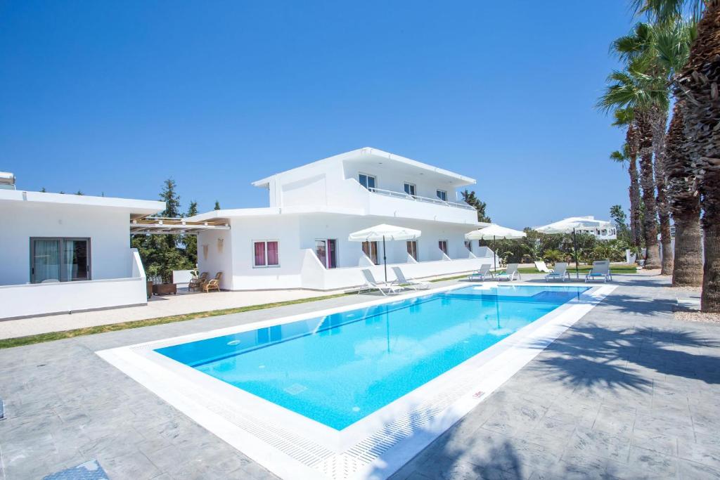 a villa with a swimming pool in front of a house at Rosie's Bellezza in Faliraki