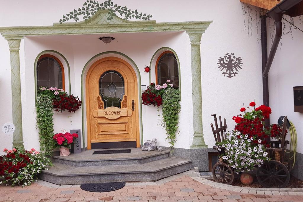 ザンクト・アントン・アム・アールベルクにあるAm Mühlrainの木の扉と花の家