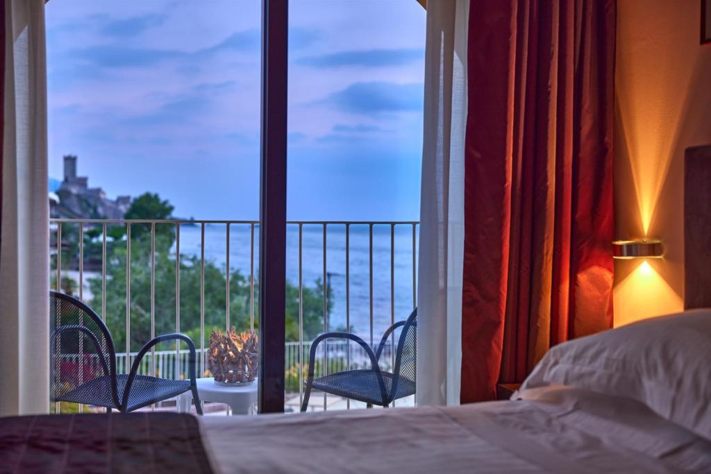 1 dormitorio con cama y vistas a un balcón en Hotel Europa, en Malcesine