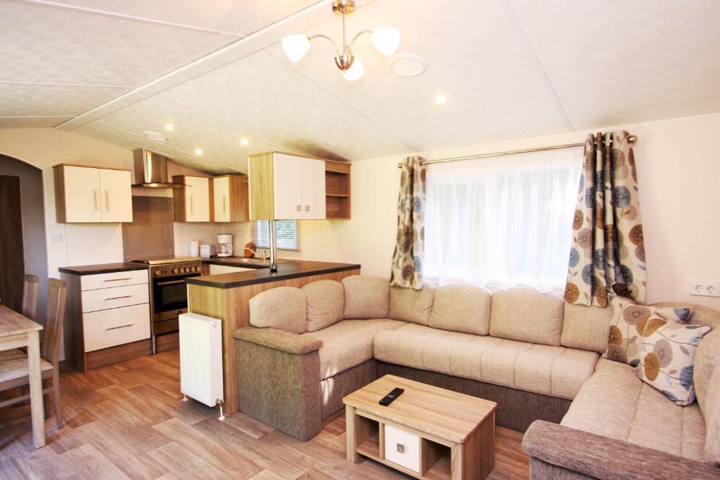 a living room with a couch and a kitchen at schönes Chalet Tinyhouse in Ostseenähe 13km - sehr ruhige Dorflage in Vogtshagen