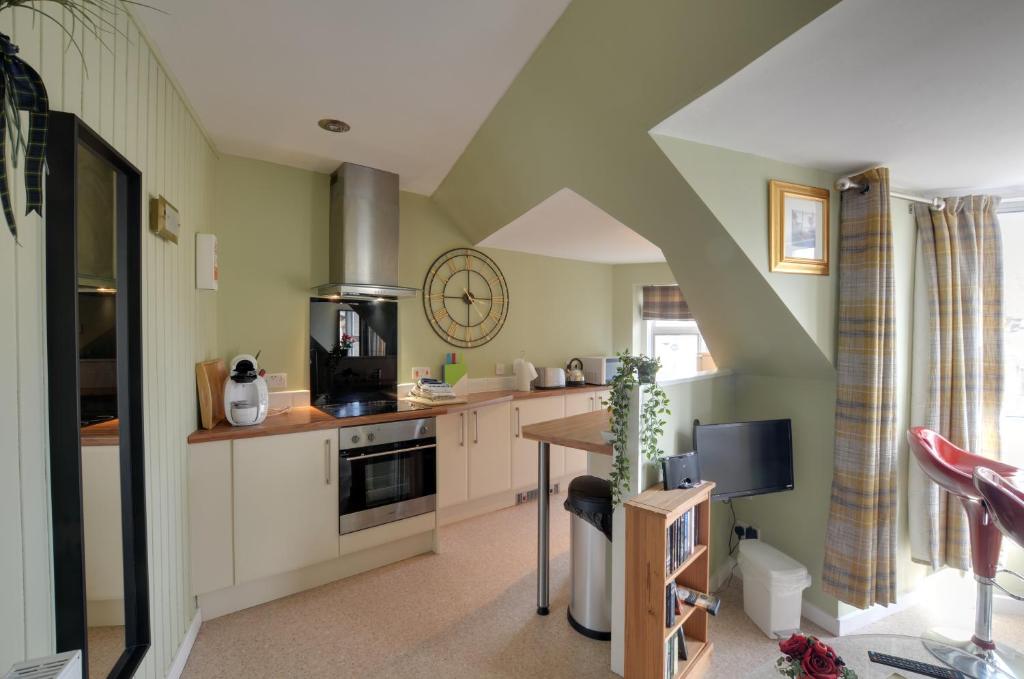 a kitchen with white cabinets and a table at King Street Apartment in Inverness