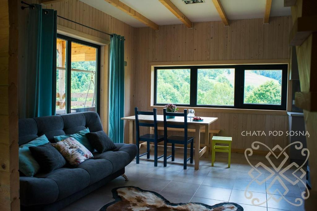 a living room with a couch and a table at CHATA POD SOSNĄ in Czaszyn