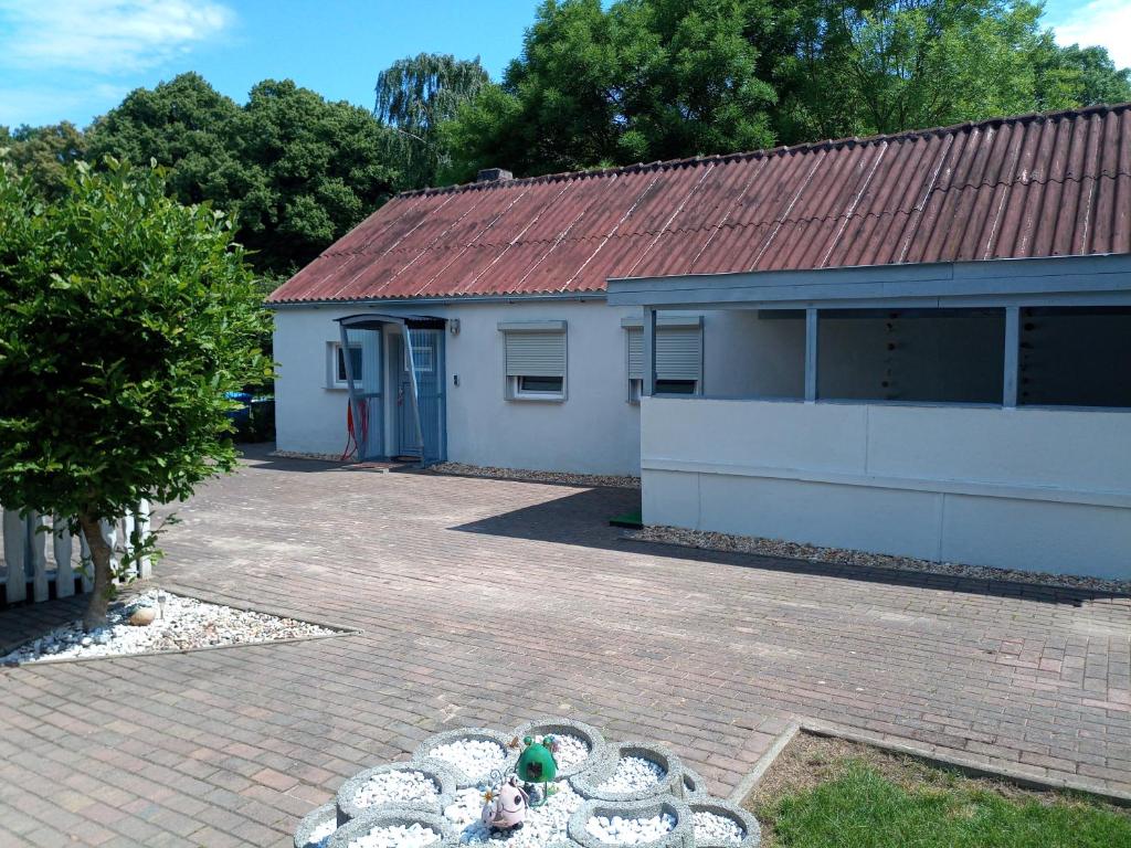 una casa con techo rojo y entrada de ladrillo en kleines gemütliches Ferienhaus, en Poseritz