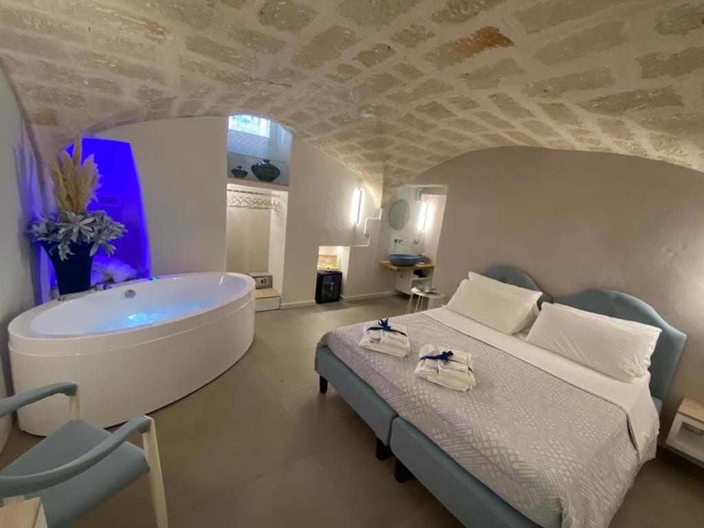 a bedroom with a large bed and a bath tub at Sogno D'Epoca 1822 in Monopoli