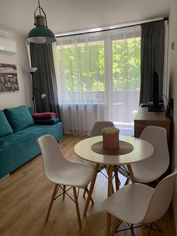 sala de estar con mesa, sillas y sofá en SEN na CICHEJ - Apartamenty w PARKU, en Polanica-Zdrój