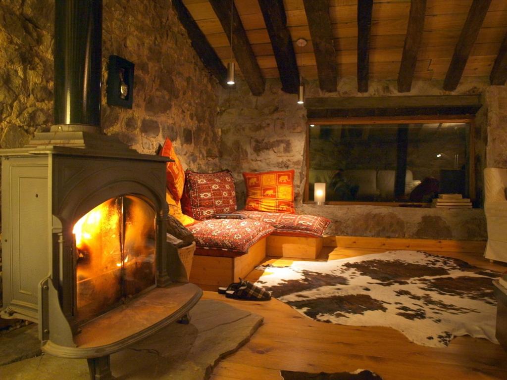 sala de estar con chimenea y sofá en Cabañas con Encanto, en San Roque de Ríomiera