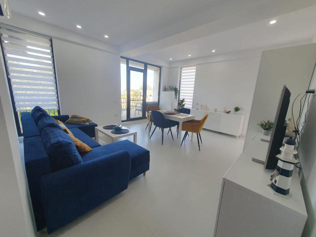 a living room with a blue couch and a table at Sea view Oxygen Neptun in Neptun