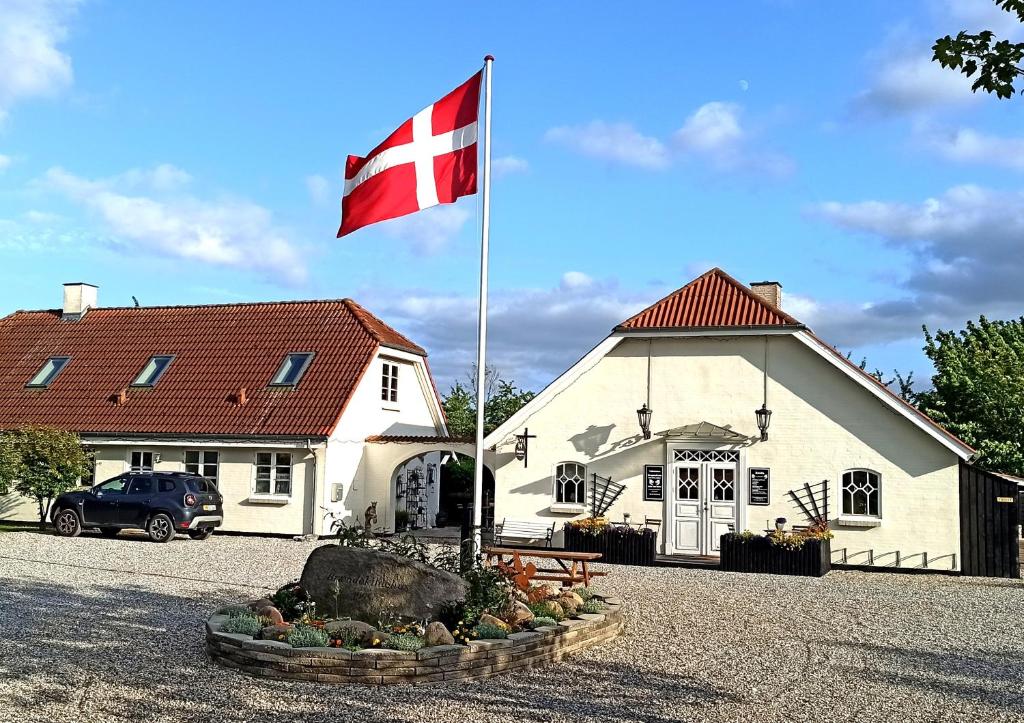 a flag in front of a white building with a flag at Dragondrum Bed & Kitchen in Ullerslev
