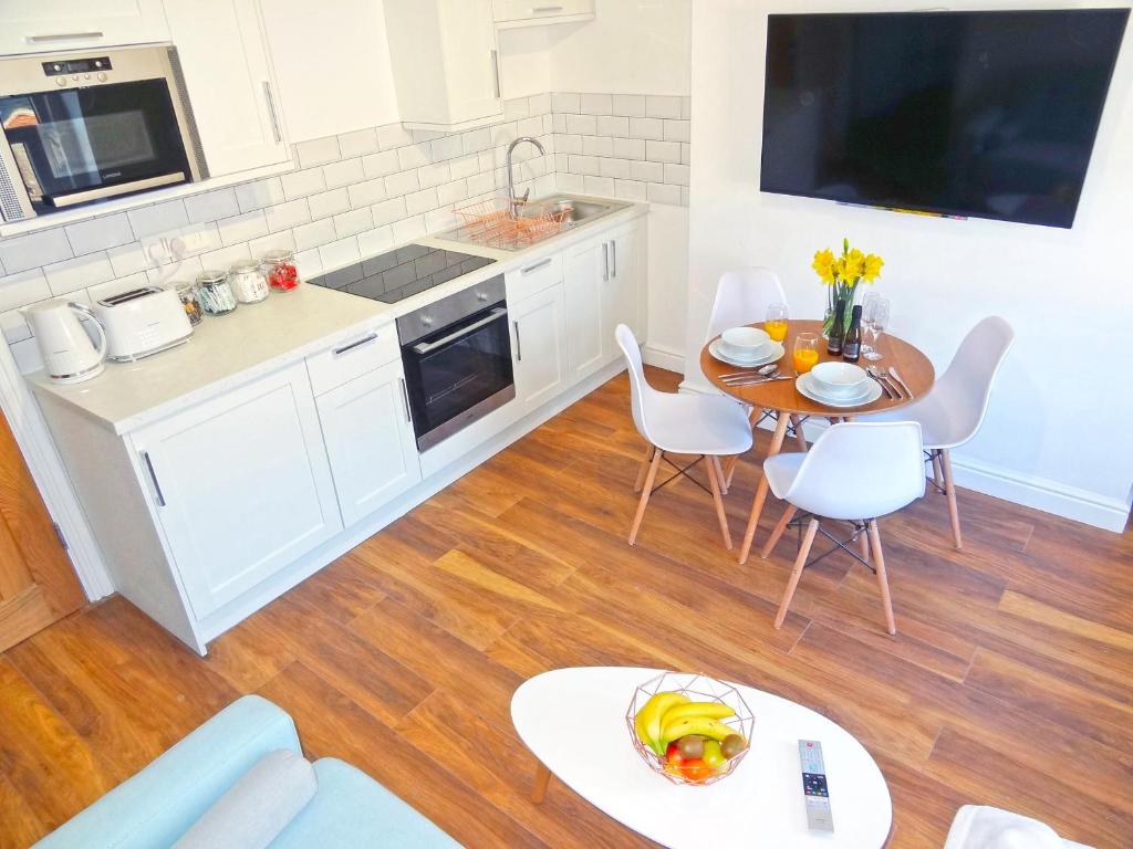 cocina y comedor con mesa y sillas en Great Orme Apartment by Seaside Llandudno, en Llandudno