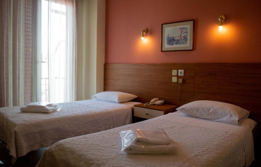 um quarto de hotel com duas camas e uma janela em Egnatia Hotel em Ioannina